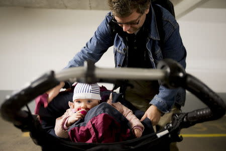 Peter Talos adjusts the pram of his daughter Karin, as they spend time together during his parental leave, in Oslo, October 5, 2012. REUTERS/Heiko Junge/NTB Scanpix