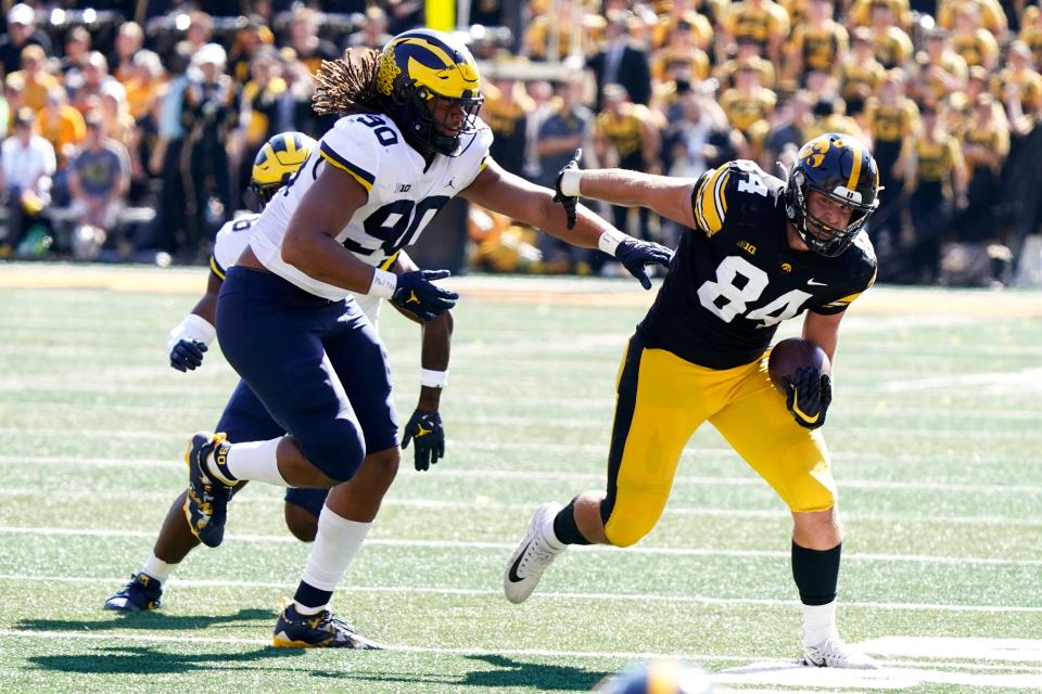 Iowa tight end Sam LaPorta (84) runs from Michigan linebacker Mike Morris (90) after catching a pass during the second half of an NCAA college football game, Saturday, Oct. 1, 2022, in Iowa City, Iowa. Michigan won 27-14. (AP Photo/Charlie Neibergall)