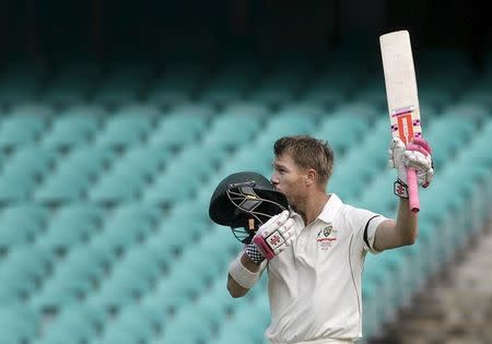 Australian batsman David Warner kisses his helmet in celebration after scoring a century against the West Indies on the final day of their third cricket test in Sydney January 7, 2016. REUTERS/Jason Reed