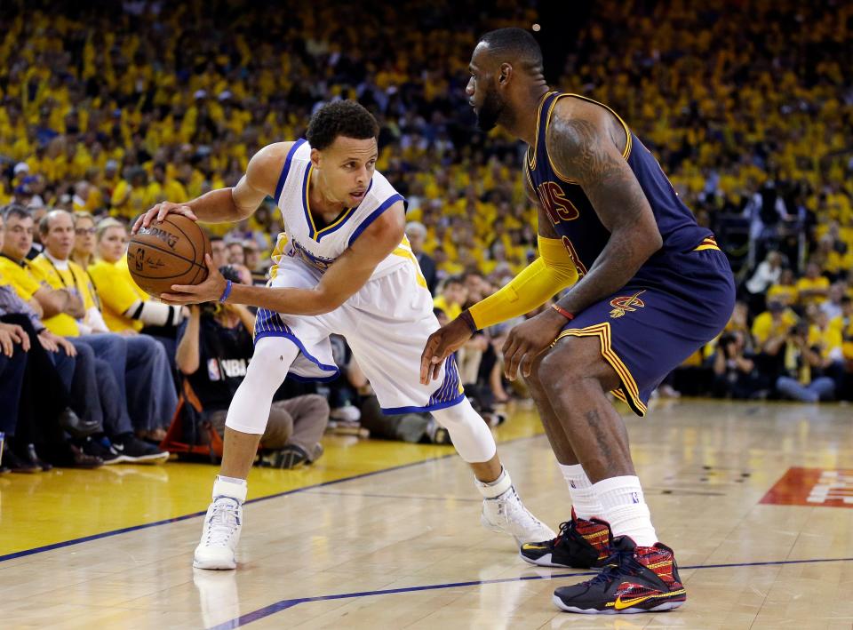 Warriors guard Stephen Curry, left, is guarded by Cavaliers forward LeBron James during Game 5 of basketball's NBA Finals in Oakland, Calif. on June 14, 2015.