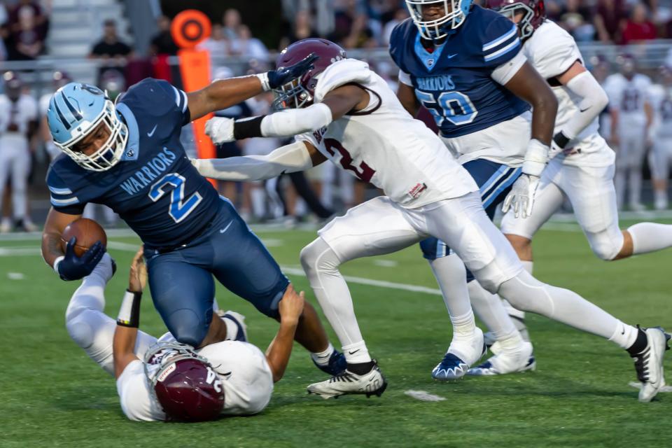 Central Valley running back Jance Henry (2) gets upended by Beaver Area's Drey Hall (24) and Amari Jackson (2) Friday night during the Warriors Western Hills Conference game at Sarge Alberts Stadium.