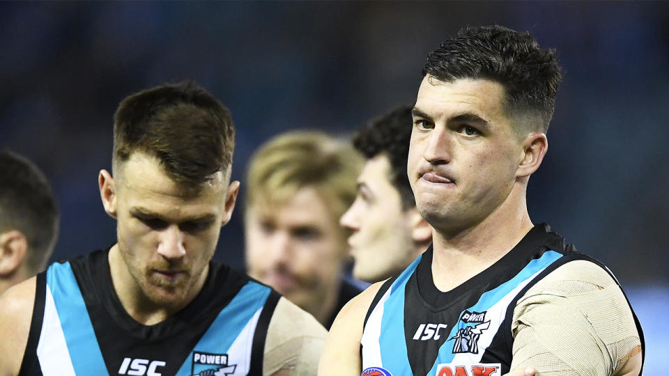 Tom Rockliff (pictured right) and his Power team mates look dejected.