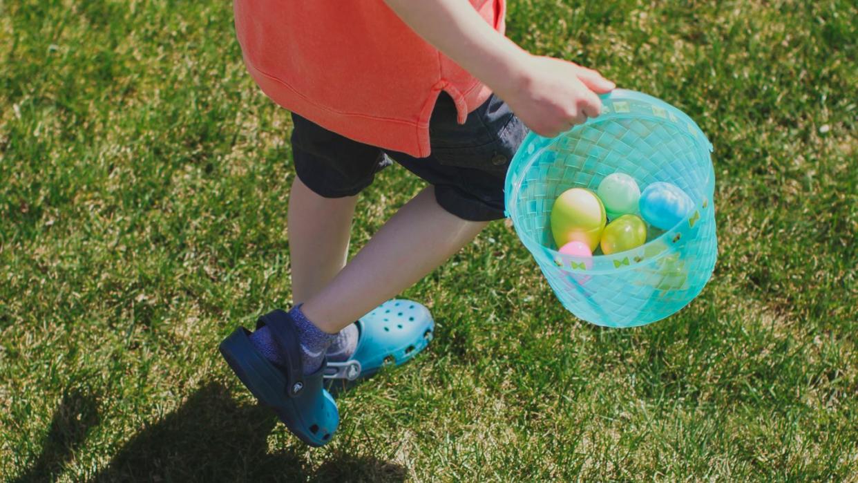 kid holding blue easter basket wearing crocs