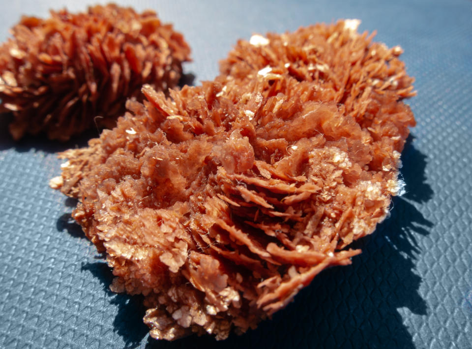 Red crystals of natural tartar formed at bottom of glass container with grape juice. Potassium Tartrate. Potassium salt of tartaric acid. Natural wine stone on gray background. Selective focus