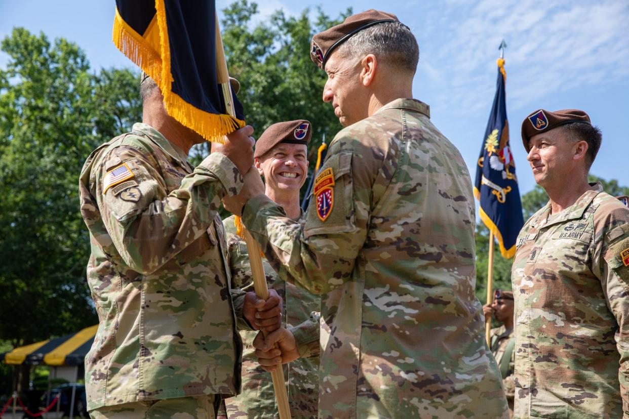 At right, Maj. Gen. Scott Jackson relinquishes command of the Security Force Assistance Command to Maj. Gen. Donn Hill, center, during a May 16, 2022, ceremony at Fort Bragg.