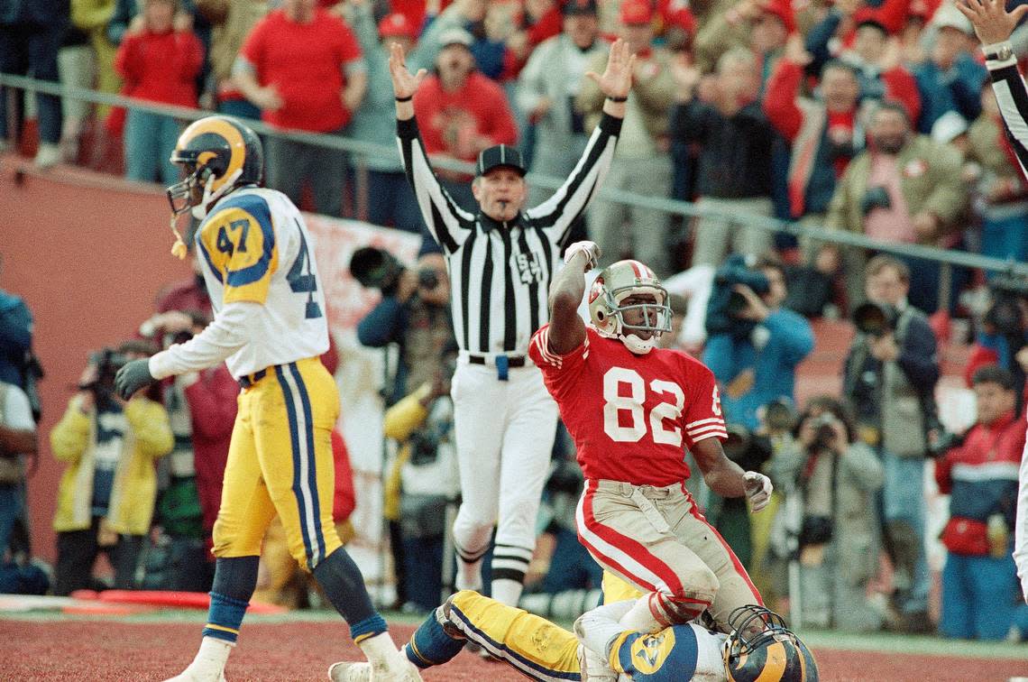 San Francisco 49ers wide receiver John Taylor sits atop Los Angeles Rams safety James Washington as he celebrates a touchdown pass from Joe Montana in the second quarter at Candlestick Park, Sunday, Jan. 15, 1990, San Francisco, Calif. The 49ers beat the Rams 30-3 to head to the Super Bowl in New Orleans. (AP Photo/Bob Galbraith) Bob Galbraith/AP