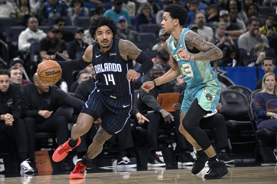 Orlando Magic guard Gary Harris (14) is defended by Charlotte Hornets guard Tre Mann (23) during the first half of an NBA basketball game, Tuesday, March 19, 2024, in Orlando, Fla. (AP Photo/Phelan M. Ebenhack)