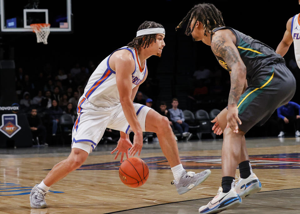 Florida guard Walter Clayton Jr., left, drives past Baylor guard Jayden Nunn, right, during the first half of an NCAA college basketball game in the NIT Season Tip-Off, Friday, Nov. 24, 2023, in New York. (AP Photo/Eduardo Munoz Alvarez)