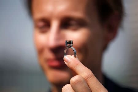 Dutch artist and innovator Daan Roosegaarde holds the Smog Free Ring made of compressed smog particles collected by the world's largest smog vacuum cleaner as he presents his The Smog Free Project at D-751 art zone in Beijing September 29, 2016. REUTERS/Damir Sagol