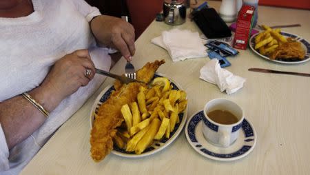 A woman eats fish and chips at Jack's Fish & Chips in west London May 18, 2012. REUTERS/Eddie Keogh/Files