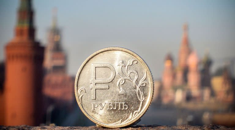 Una moneda de rublo ruso se muestra frente al Kremlin en el centro de Moscú. El rublo se fortaleció tras una brusca caída al comienzo de la guerra 