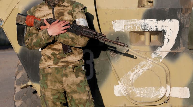 Service members of pro-Russian troops stand guard in Mariupol