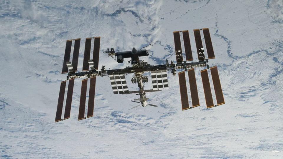  A view of the international space station and its solar panels in front of earth. 