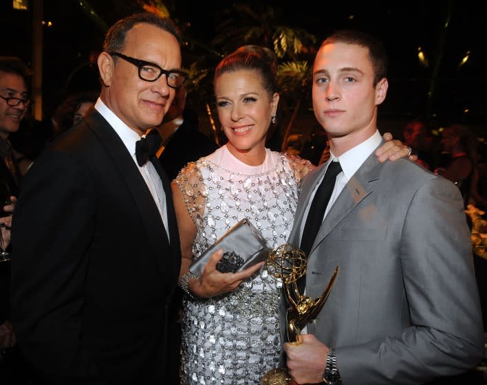 Tom Hanks, Rita Wilson and Chet Hanks posing for a photo in a dark room