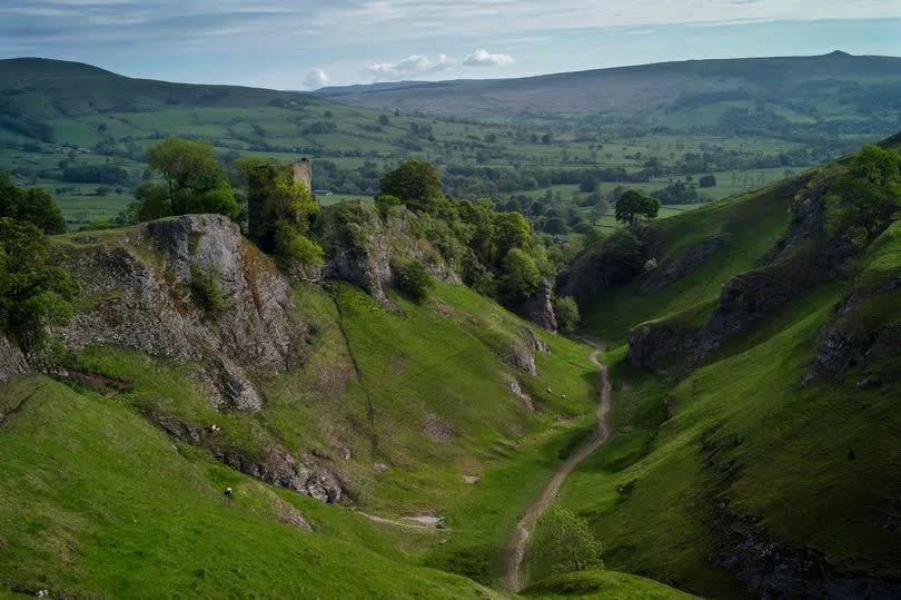 A view from Cave Dale across the Peak District with Peveril Castle to the left