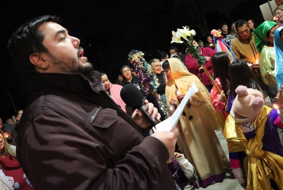 El Padre Agustín Carrillo dirige a un grupo cantando durante la posada organizada por la Iglesia de San Antonio María Claret en el sureste de Fresno, el 18 de diciembre de 2023.