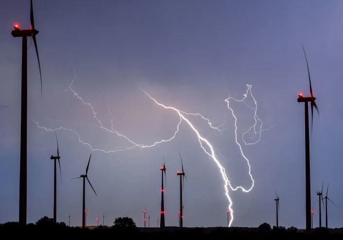 Lightning strikes close to wind turbines in a wind energy park during a thunderstorm near Sieversdorf, eastern Germany, on August 28, 2016. / AFP PHOTO / dpa / Patrick Pleul / Germany OUT        (Photo credit should read PATRICK PLEUL/DPA/AFP via Getty Images)
