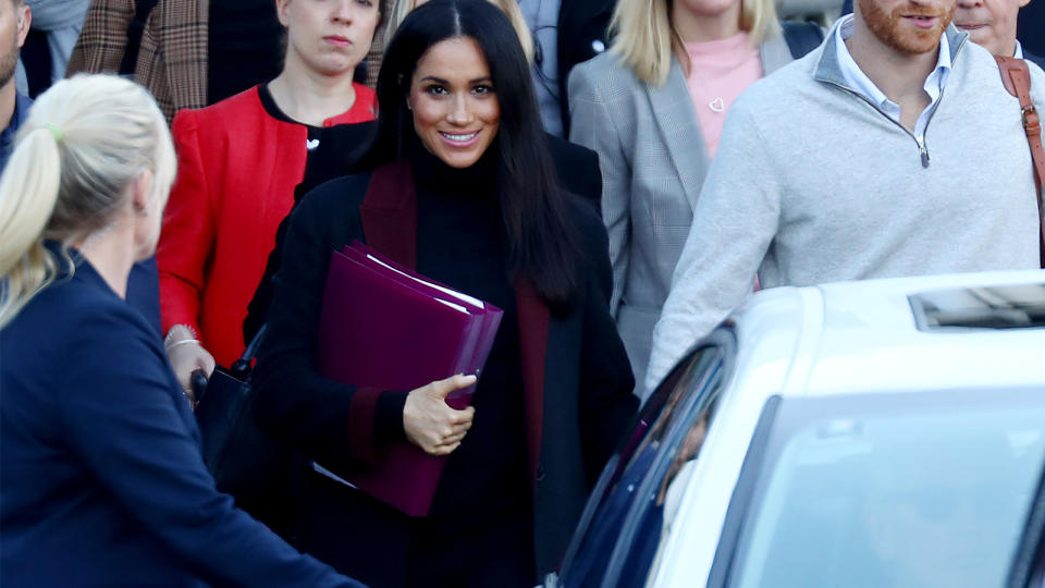 Meghan Markle set tongues wagging by carrying a couple of folders in front of her tummy when she got to Sydney. Picture: Getty