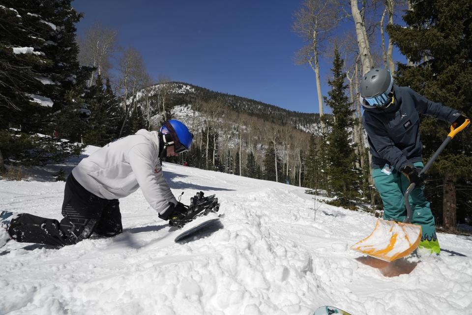 Race Lessar, left, and Landen Ozzello build a jump at Parker-Fitzgerald Cuchara Mountain Park on Sunday, March 19, 2023, near Cuchara, Colo. Some communities including Cuchara are now finding a niche, offering an alternative to endless lift lines and sky-high ticket prices. They're reopening, several as nonprofits, offering a mom-and-pop experience at a far lower cost than mountains run by corporate conglomerates. (AP Photo/Brittany Peterson)