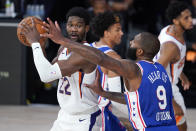 Phoenix Suns center Deandre Ayton (22) looks for help as Philadelphia 76ers center Kyle O'Quinn (9) applies pressure during the second half of an NBA basketball game Tuesday, Aug. 11, 2020, in Lake Buena Vista, Fla. (AP Photo/Ashley Landis, Pool)