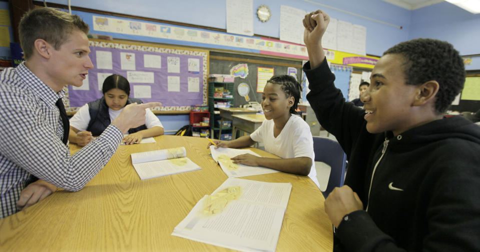 In this Monday, May 7, 2012 photo, Chad Larsen Stauber, left, a student teacher at Lafayette School in Chicago, works with students from second left, Angela Rios, Jovante Ross, and Devion Allen, on their reading skills. The 26-year-old who just received his master's degree in education knows that later in 2012, he'll have to start paying off debt of about $100,000. "This is going to be looming over my head the next 20 years," Larsen-Stauber says. "You've borrowed all of this money and it just comes due all of a sudden. When you're already going into a low-wage job and you know that a third of your salary is immediately going to be eaten up ... that's really frightening." It seems overwhelming, but he says, “there never has been a regret in my mind. I knew when I started this program, I was 100 percent sure. ... If there was one job that I ever wanted, it was to be a teacher." (AP Photo/M. Spencer Green)