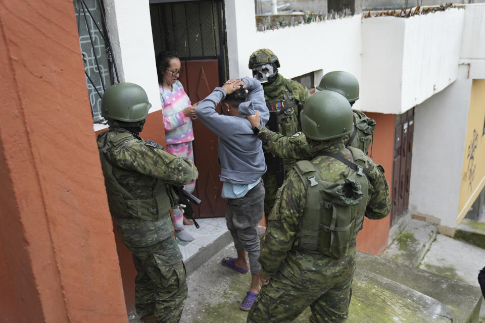 Una mujer busca sin éxito una copia del documento de identidad que perdió su hijo, antes de que los militares lo revisaran para ver si tenía tatuajes relacionados con las pandillas y lo liberaran al ver que no tenía, durante un patrullaje por el sur de Quito, Ecuador, el viernes 12 de enero de 2024, como secuela a la fuga de dos cabecillas de bandas criminales de prisión. El presidente Daniel Noboa decretó el lunes el estado de emergencia nacional debido a la violencia, que permite a las autoridades suspender derechos ciudadanos y movilizar a los militares. (Foto AP/Dolores Ochoa)