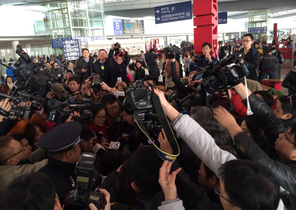 Reporteros se apiñan en la terminal 3 del aeropuerto internacional Capital Beijing en Beijing, China, el sábado 8 de marzo de 2014, adonde debía llegar un avión con 239 personas a bordo que despegó de Kuala Lumpur, Malasia, y que desapareció en vuelo. (AP Foto/Xinhua, Luo Xiaoguang)