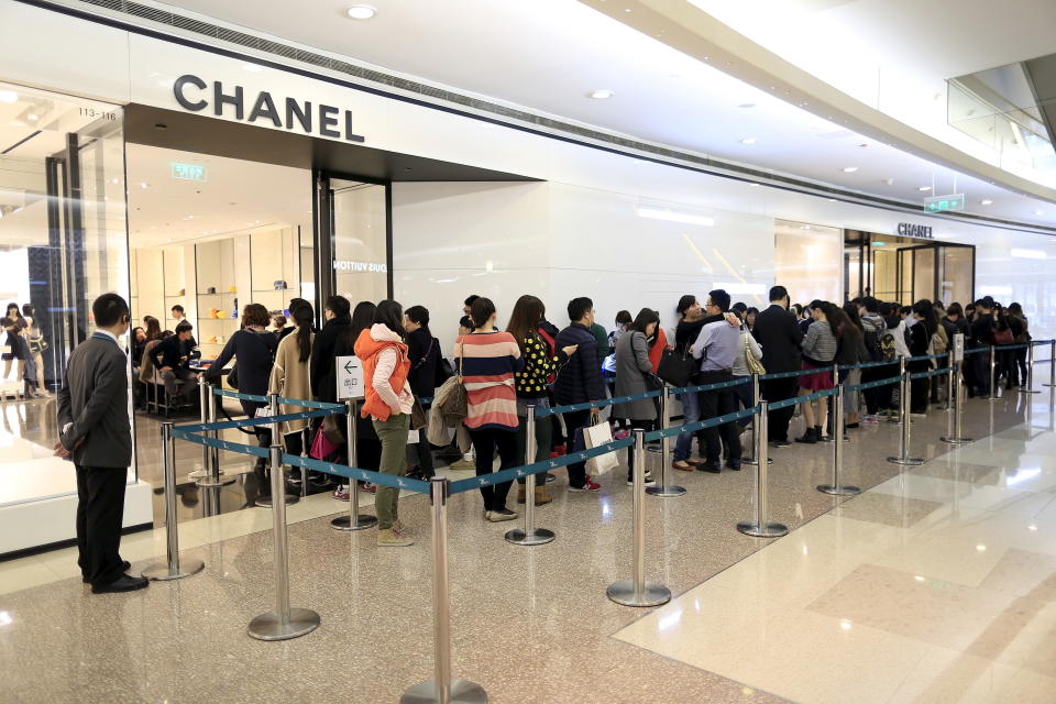 Customers line up as they wait to go inside a Chanel shop at a shopping mall in Shanghai March 19, 2015. Global luxury brands expanding in China are better off targeting the HENRYs - "high earners, not rich yet" - instead of the ultra-wealthy, as a slowing economy and a government that frowns on official excesses usher in an era of less showy spending. REUTERS/Aly Song