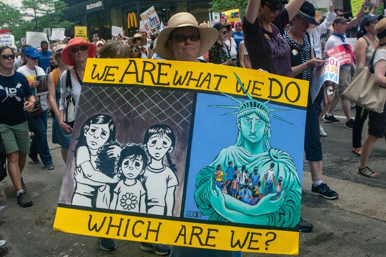 Woman holding poster protesting against Trump administration's family separation policy.