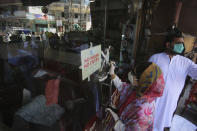 Government officials seal shut a barber shop for not observing the standard operating procedures issued by the Pakistan government to contain the spread of coronavirus, in Peshawar, Pakistan, Thursday, June 4, 2020. (AP Photo/Muhammad Sajjad)