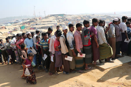 Rohingya refugees stand in a queue to collect aid supplies in Kutupalong refugee camp in Cox's Bazar, Bangladesh, January 21, 2018. REUTERS/Mohammad Ponir Hossain