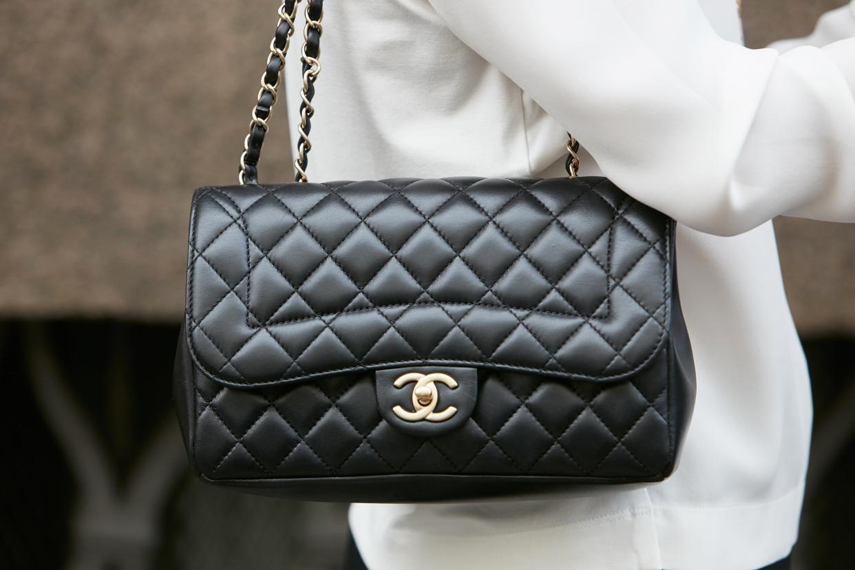 woman with Chanel black leather bag