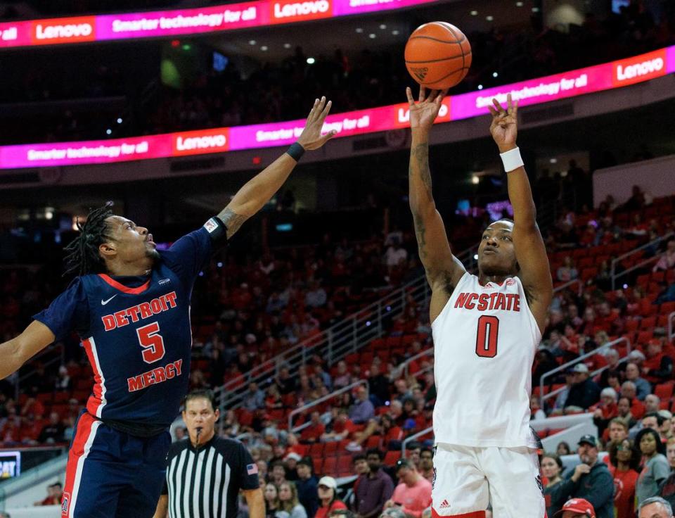 N.C. State’s DJ Horne shoots over Detroit’s Kyle LeGreair during the first half of the Wolfpack’s 83-66 win on Saturday, Dec. 23, 2023, at PNC Arena in Raleigh, N.C.