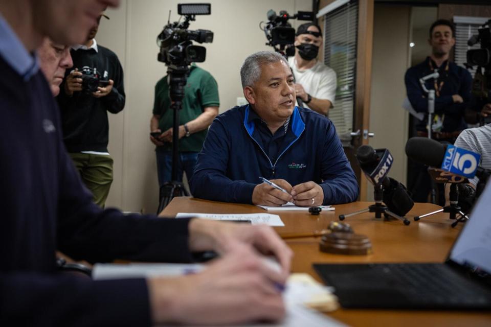 Chuck Ruiz speaks surrounded by cameras.