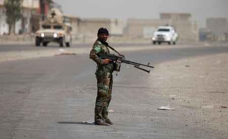 A member of the Shi'ite Badr Organisation carries his weapon in Saqlawiya, north of Falluja, Iraq, June 5, 2016. REUTERS/Thaier Al-Sudani