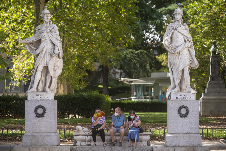 People rest on a bench during a heatwave in Madrid, Spain, Friday, Aug. 13, 2021. Stifling heat is gripping much of Spain and Southern Europe, and forecasters say worse is expected to come. (AP Photo/Andrea Comas)