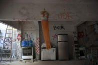 A half torso mannequin decorated with an orange veil hangs from a beam backdropped by donated items in the courtyard of the squat known as Casa Nem, occupied by members of the LGBTQ community who are in self-quarantine as a protective measure against the new coronavirus, in Rio de Janeiro, Brazil, Wednesday, July 8, 2020. They receive food donations as well and are barred from leaving unless facing medical emergency or other exceptional circumstances. (AP Photo/Silvia Izquierdo)