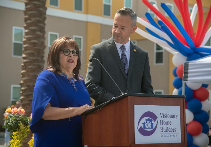 Visionary Home Builders CEO Carol Ornelas, left, and board President Scott Beiderman speak during the grand opening ceremony for the Liberty Square low-income housing development in downtown Stockton.