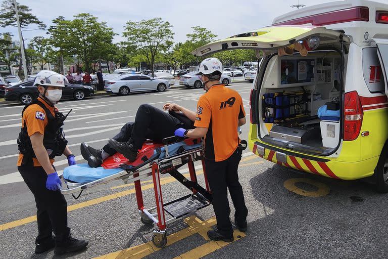 Personal de emergencia traslada a un pasajero en una camilla a una ambulancia en el Aeropuerto Internacional de Daegu, en Corea del Sur, viernes 26 de mayo de 2023.