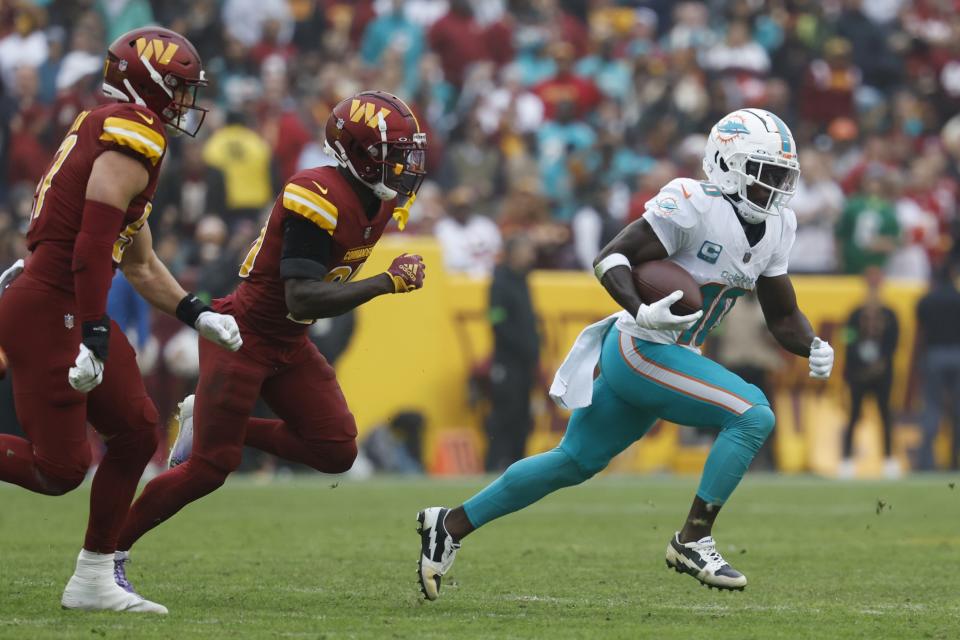 Dec 3, 2023; Landover, Maryland, USA; Miami Dolphins wide receiver Tyreek Hill (10) runs with the ball as Washington Commanders safety <a class="link " href="https://sports.yahoo.com/nfl/players/40087" data-i13n="sec:content-canvas;subsec:anchor_text;elm:context_link" data-ylk="slk:Jartavius Martin;sec:content-canvas;subsec:anchor_text;elm:context_link;itc:0">Jartavius Martin</a> (20) chases during the second quarter at FedExField. Mandatory Credit: Geoff Burke-USA TODAY Sports
