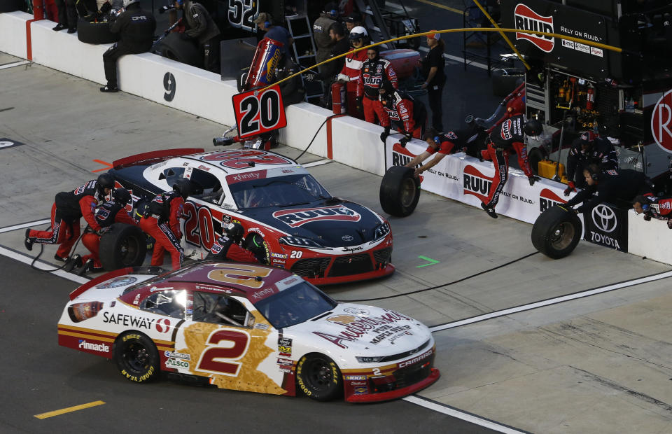 Tyler Reddick (2) heads into the pits as Christopher Bell (20) makes a pits stop during the NASCAR Xfinity Series auto race at Richmond Raceway in Richmond, Va., Friday, April 12, 2019. (AP Photo/Steve Helber)