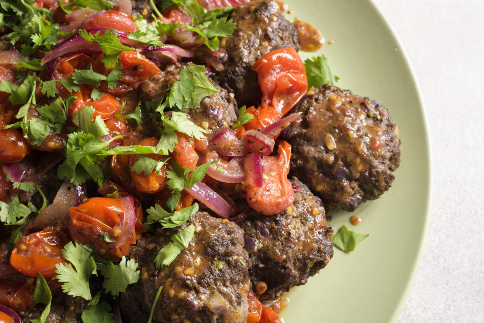 This image released by Milk Street shows a recipe for Spicy Ground Beef Kebabs w/Tomato-Sumac Sauce. (Milk Street via AP)