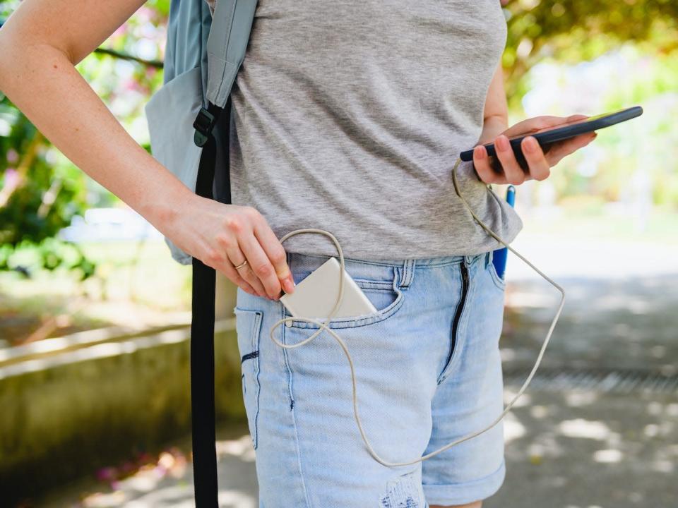 A tourist connect smartphone to power bank.