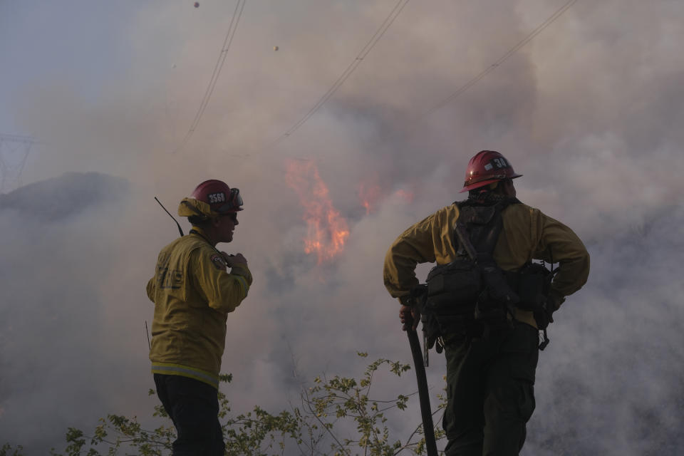 Firefighters watch as the South Fire burns in Lytle Creek, San Bernardino County, north of Rialto, Calif., Wednesday, Aug. 25, 2021. (AP Photo/Ringo H.W. Chiu)
