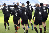 Frankfurt's players wear the pictures and names of the victims of the shooting in Hanau a year ago on their training jackets, prior to the German Bundesliga soccer match between Eintracht Frankfurt and Bayern Munich in Frankfurt, Germany, Saturday, Feb. 20, 2021. A right-wing extremist shot dead nine people in Hanau on 19 Feb. 2020, before shooting himself. (Arne Dedert/POOL via AP)