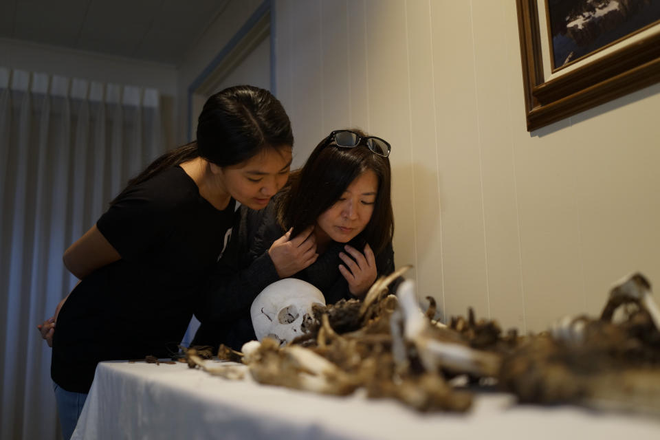 Lori Matsumura, right, and her niece, Lilah Matsumura, look at the bones of their ancestor, Giichi Matsumura, at Brune Mortuary in Bishop, Calif., Monday, Feb. 17, 2020. Giichi Matsumura was a prisoner at the Manzanar internment camp during World War II and died on a hike in the Sierra in the waning days of the war in August 1945. Hikers discovered his mountainside grave and unearthed the skeleton in 2019, leading authorities to retrieve the bones and return them to the Matsumura family. (AP Photo/Brian Melley)