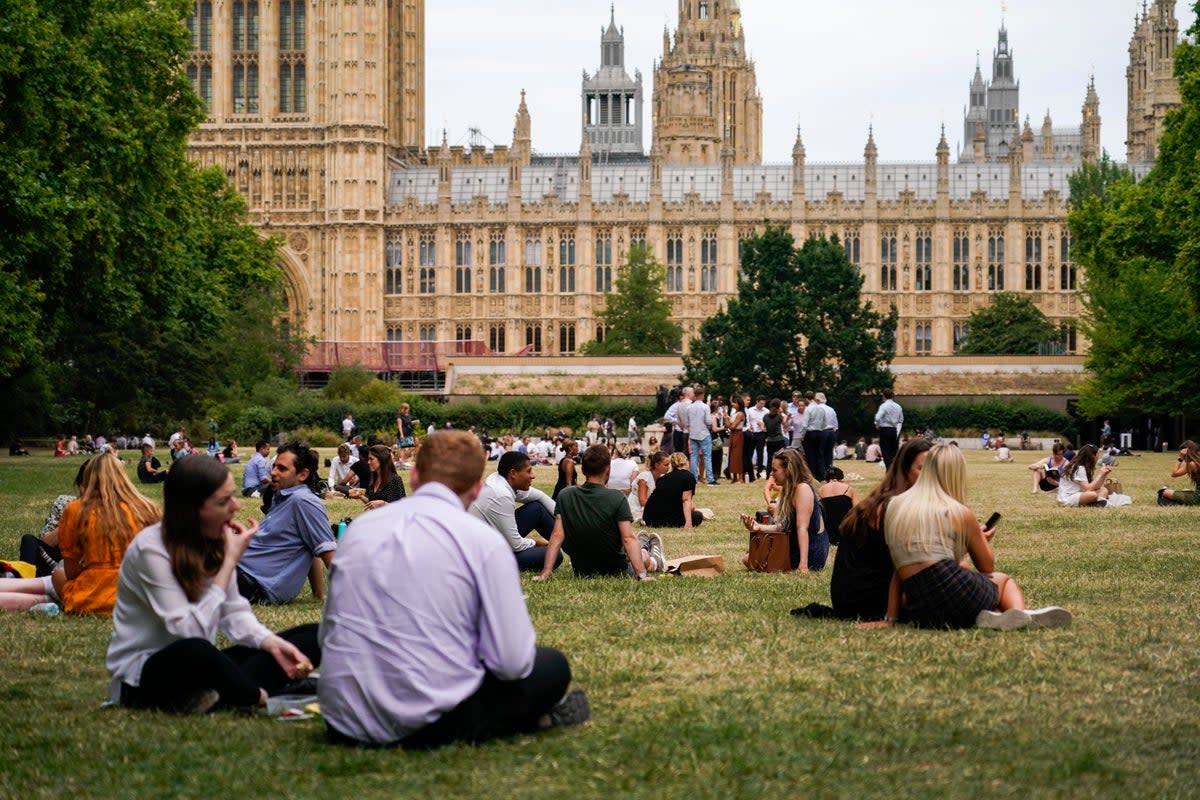 People have lunch sitting on the grass in Victoria Tower Gardens (AP)