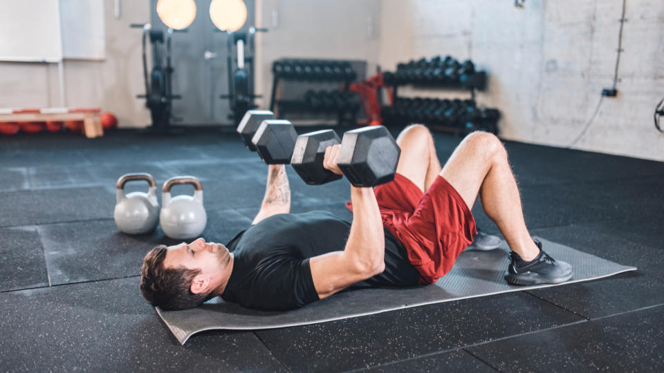 A man performing a dumbbell floor press