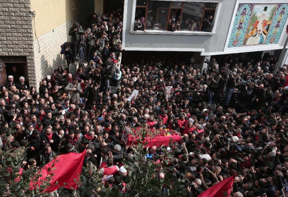 People carry the coffin of Berkin Elvan, a Turkish teenager who was in a coma since being hit on the head by a tear gas canister fired by police during anti-government protests in the summer of 2013, as family members watch from a window, during his funeral in Istanbul, Turkey, Wednesday, March 12, 2014. On Wednesday, thousands converged in front of a house of worship calling for Prime Minister Recep Tayyip Erdogan to resign.(AP Photo/Emrah Gurel)