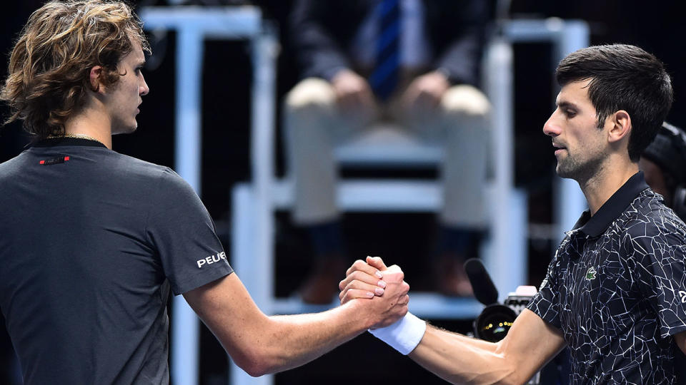Novak Djokovic (R) shakes hands at the net with Alexander Zverev. (Photo by Glyn KIRK / AFP / Getty)